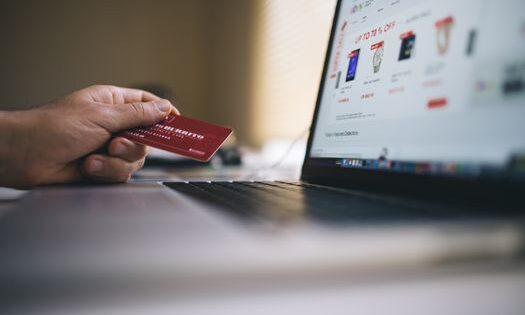 pexels-photo-34577 Person holding a credit card while shopping online on a laptop, indicating ecommerce transactions.
